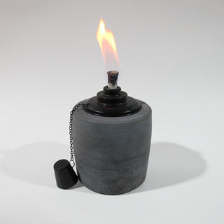 Gartenfackel in Anthrazit mit 13cm Durchmesser und 19cm Hoch. Der schwarze Einsatz des Ölbrenners erzeugt eine schöne gleichmäßige Flame. Der Löschdeckel hängt an einer feinen Kette auf der linken Seite herunter.