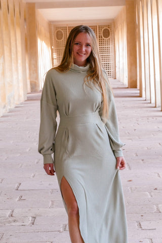 Fair produziertes und weibliches Winterkleid das bis zum Boden geht und einen Schlitz hat