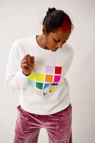 Unisex Sweatshirt mit multicolor glänzendem Folienprint aus 16 Quadraten auf der Front, inspiriert von Gerhard Richter, frontal vor neutralem Hintergrund fotografiert.
