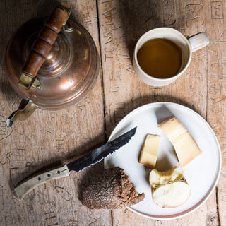 Steingut Teller in Beige mit Käse, Apfel und Brot.