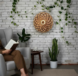 Gofurnit Veneria walnut wood lampshade with a spiral Fibonacci design, emitting warm light.