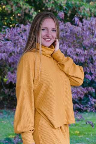 Weicher Damenpullover in sonnigem Amberton mit Rollkragen und Schlitzen an den Seiten