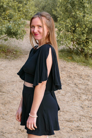 Schwarzes Kurzarmtop mit offenen Ärmeln und Rüschensuam