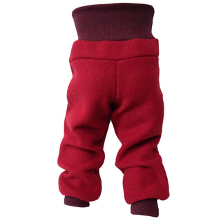 Rote Kinderhose aus Bio-Wollwalk mit breiten, mitwachsenden Bündchen, die in Herbst und Winter kuschelig wärmt, Bewegungsfreiheit bietet und aus nachhaltigen Naturmaterialien gefertigt ist.
