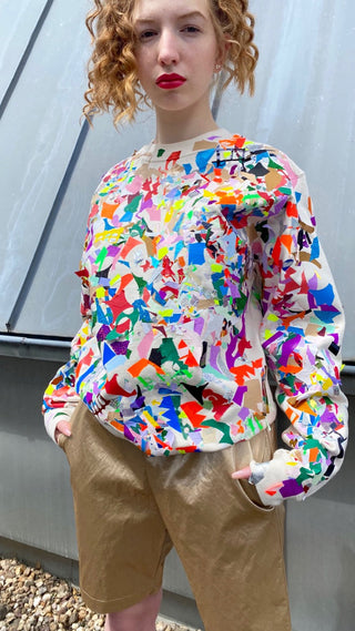 Unisex Sweater mit geschichteten Rest‑Foliestücken allover; bewusst lose Enden für entwickelnden Look, spürbare Textur, weicher Sweat – eine Größe größer bestellen.
