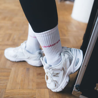 Kokolores Statementsocken von arrel mit Sneaker auf Holzboden