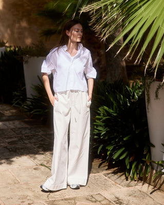 Kurze Damen Hemdbluse in Weiß aus Bio-Baumwolle von WOTE, locker geschnitten und am Model getragen, Outdoor Editorial Aufnahme.