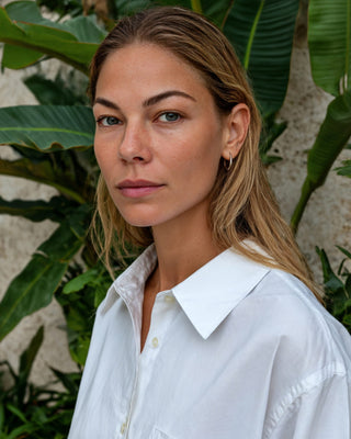Kurze Damen Hemdbluse in Weiß aus Bio-Baumwolle, Nahaufnahme am Model vor tropischem Grün.