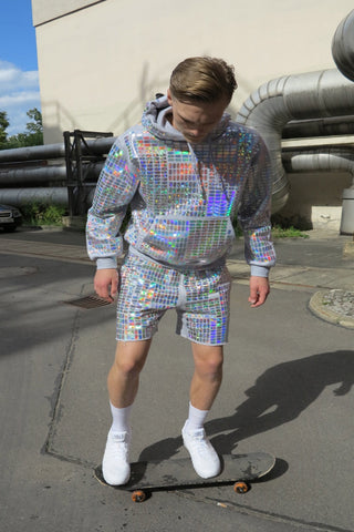 Unisex Shorts mit glänzendem Pillen‑Allover‑Foilprint auf weichem Sweat; relaxed Jogger‑Fit, leicht, bewegungsfreundlich und auffällig im Licht.
