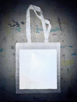 Baumwoll-Tote-Bag ca. 40 x 36 cm mit großem weiß reflektierendem Quadrat auf der Vorderseite, frontal fotografiert vor neutralem Hintergrund.
