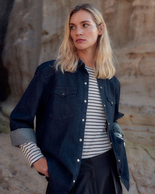 Anschnitt eines off-white-schwarz gestreiften Damen Longsleeves aus Bio-Baumwolle von WOTE, kombiniert mit einem dunklen Jeanshemd.