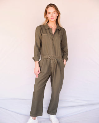 Olivfarbener Damen Utility Overall aus Bio-Baumwolle von WOTE, stehende Studioaufnahme mit lockerem Bein und Taillenband.