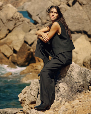 Schwarze Damenweste aus nachhaltiger Tuchwolle, kombiniert mit weiter schwarzer Hose in ruhigem Editorial-Look.