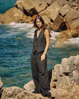 Schwarze Damenweste aus nachhaltiger Tuchwolle mit weiter schwarzer Hose in klarem, zeitlosem Editorial-Look.