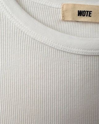Detailansicht des weißen gerippten Damen T-Shirts aus Bio-Baumwolle mit Rundhalsausschnitt und WOTE-Label.