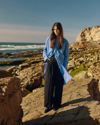 Kurz geschnittenes Hemdblusenkleid aus Bio-Baumwolle für Damen in Blau, frontal getragen als ruhiger Ganzkörperlook mit sichtbarer Länge.