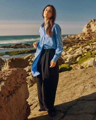 Kurz geschnittenes Hemdblusenkleid aus Bio-Baumwolle für Damen in Blau, locker getragen als Ganzkörperlook in Bewegung.