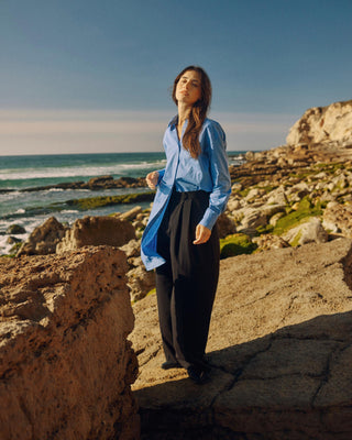 Kurz geschnittenes Hemdblusenkleid aus Bio-Baumwolle für Damen in Blau, seitlich getragen mit lockerem Fall und klarer Silhouette.