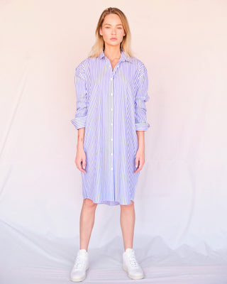 Kurz geschnittenes Hemdblusenkleid aus Bio-Baumwolle für Damen, blau-weiß gestreift, frontal im Studio mit klarer Silhouette getragen.