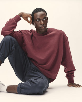 Herren Crewneck Sweatshirt in Burned Red – sitzende Pose, getragen