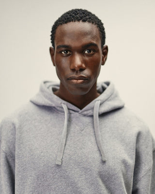 Herren Hoodie in Grau Melange im Relaxed Fit – Portrait Frontansicht mit Kapuze