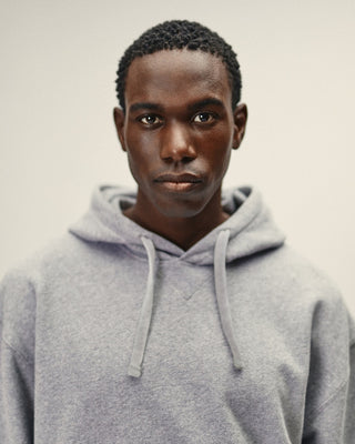 Herren Hoodie in Grau Melange im Relaxed Fit – Portrait Frontansicht mit Kapuze