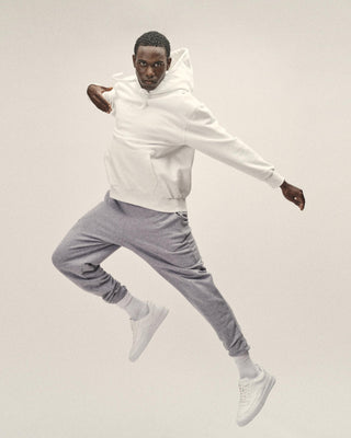 Herren Hoodie in Off White im Relaxed Fit – Frontansicht, springend getragen