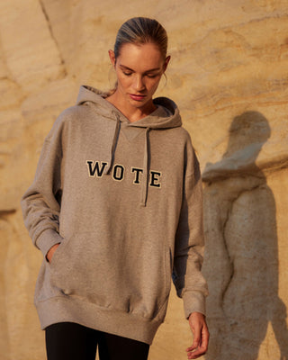 Damen WOTE Logo Hoodie in Grau Melange aus Organic Cotton, Frontansicht mit Händen in der Kängurutasche