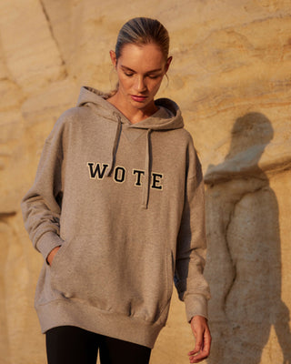 Damen WOTE Logo Hoodie in Grau Melange aus Organic Cotton, Frontansicht mit Händen in der Kängurutasche