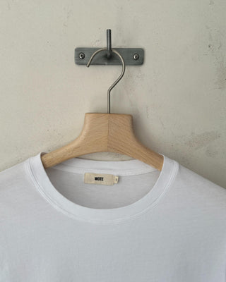 Detailaufnahme eines weißen Relaxed-Fit Rundhals T-Shirts aus Bio-Baumwolle für Damen mit Fokus auf Ausschnitt und Label.